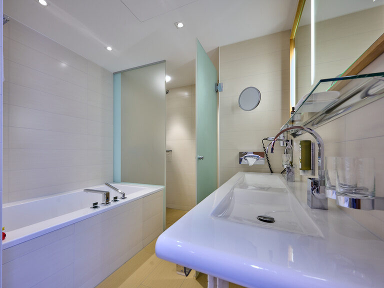 Großzügiges, helles Bad mit Dusche, Badewanne, WC und Waschbecken im 4-Sterne-S Hotel Asam Straubing.