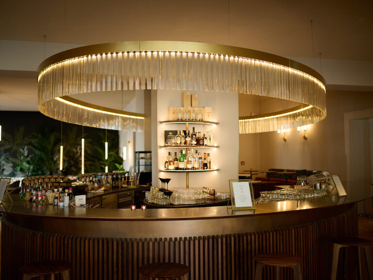 Die moderne, ovale Bar mit beeindruckender Designer-Lampe im Hotel & Restaurant ASAM in Niederbayern.