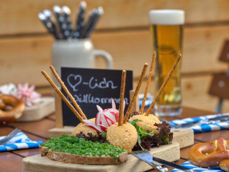 Ein Brotzeitbrett und Weißbier auf einem Tisch im Biergarten des Restaurant ASAM, Straubing. Ein Brotzeitbrett und Weißbier auf einem Tisch im Biergarten des Restaurant ASAM, Straubing.