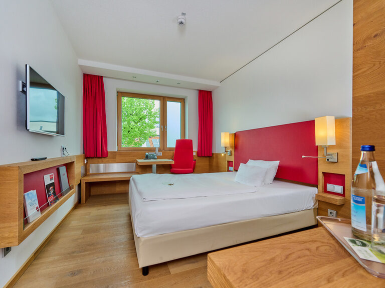 Einzelzimmer im Businesshotel Asam Straubing mit Queensize-Bett, Schreibtisch, Parkett und warmen Farben. Einzelzimmer im Businesshotel Asam Straubing mit Queensize-Bett, Schreibtisch, Parkett und warmen Farben.