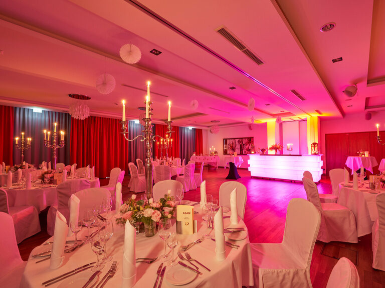 Festlich gedeckte Tische, große Tanzfläche und eine Bar in der Hochzeitslocation Hotel & Restaurant ASAM, Straubing.