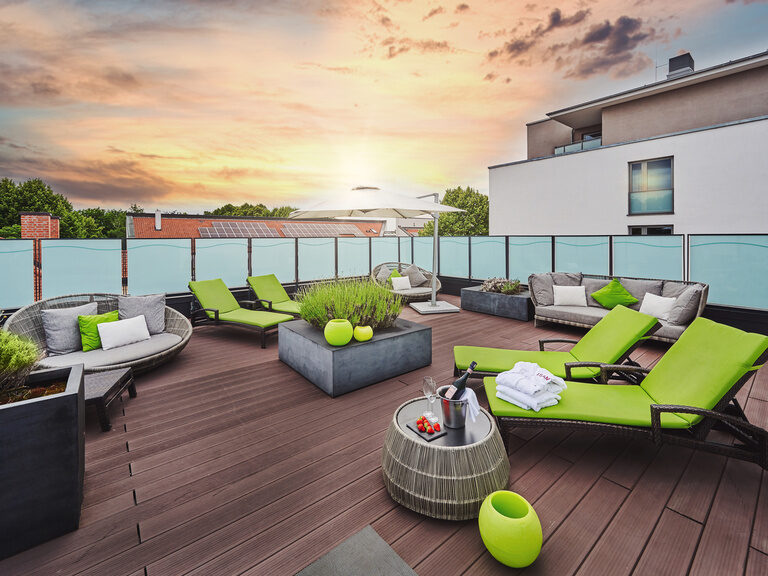 Dachterrasse des Wellnessbereiches im 4-Sterne-S Hotel Asam Straubing bei Sonnenuntergang.
