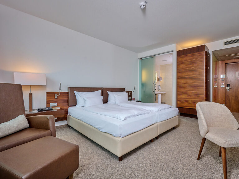 Doppelzimmer im 4-Sterne-S Hotel Asam Straubing, komfortabel eingerichtet mit Echtholzmöbeln und warmen Farben.