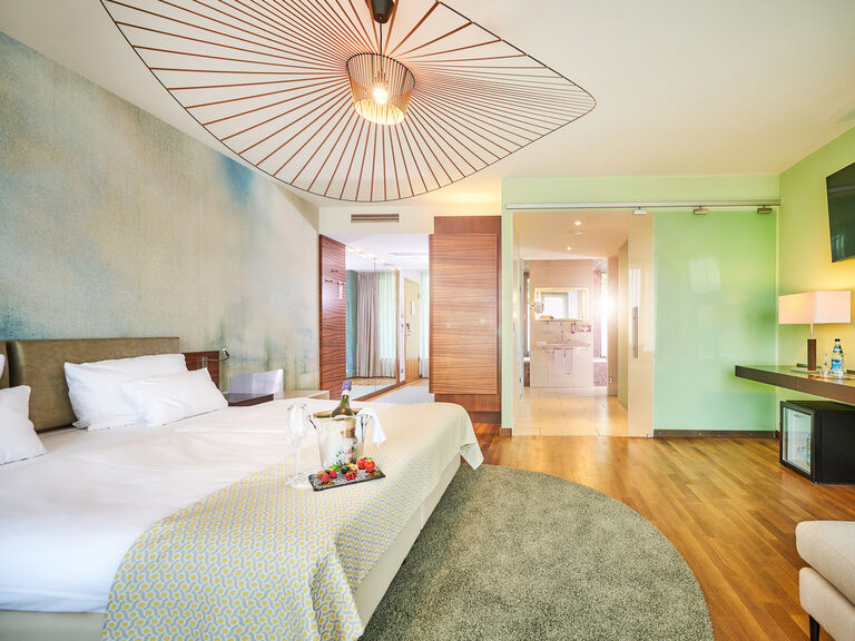 Moderne Hochzeitssuite im 4-Sterne-S Hotel Asam Straubing mit großem Bad, Sekt und Erdbeeren auf dem Bett. Moderne Hochzeitssuite im 4-Sterne-S Hotel Asam Straubing mit großem Bad, Sekt und Erdbeeren auf dem Bett.