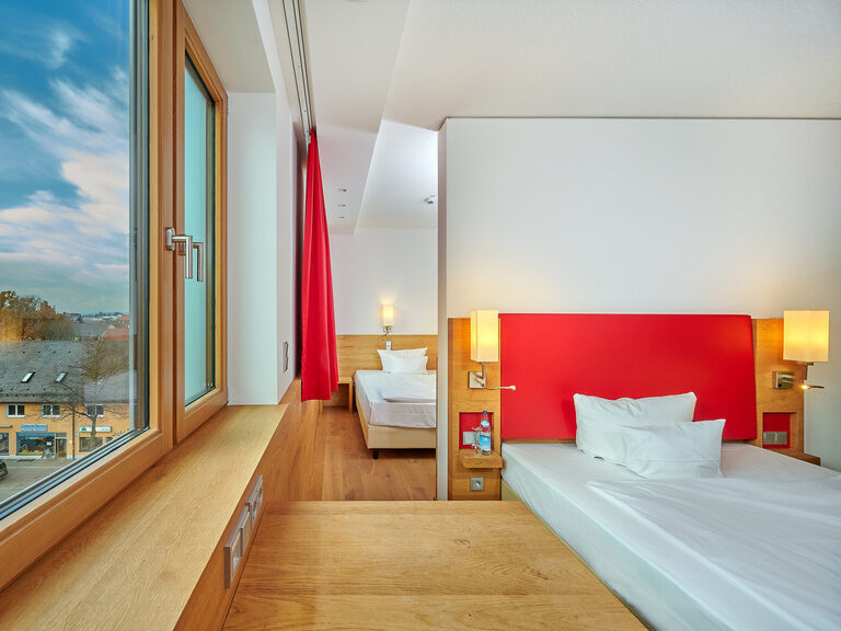 Familienfreundliches Mehrbettzimmer im 4-Sterne-S Hotel Asam Straubing mit zwei Queensize-Betten.