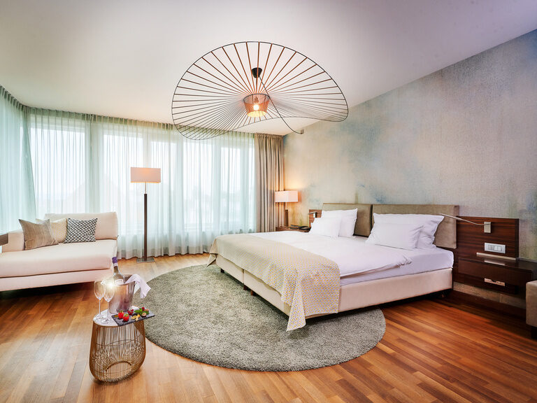 Die gemütliche Hochzeitssuite mit einem großen Bett und Holzböden schafft eine warme Atmosphäre.