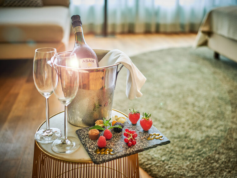 Nahaufnahme von Sekt und Erdbeeren in der Hochzeitssuite des 4-Sterne-S Hotel Asam Straubing.