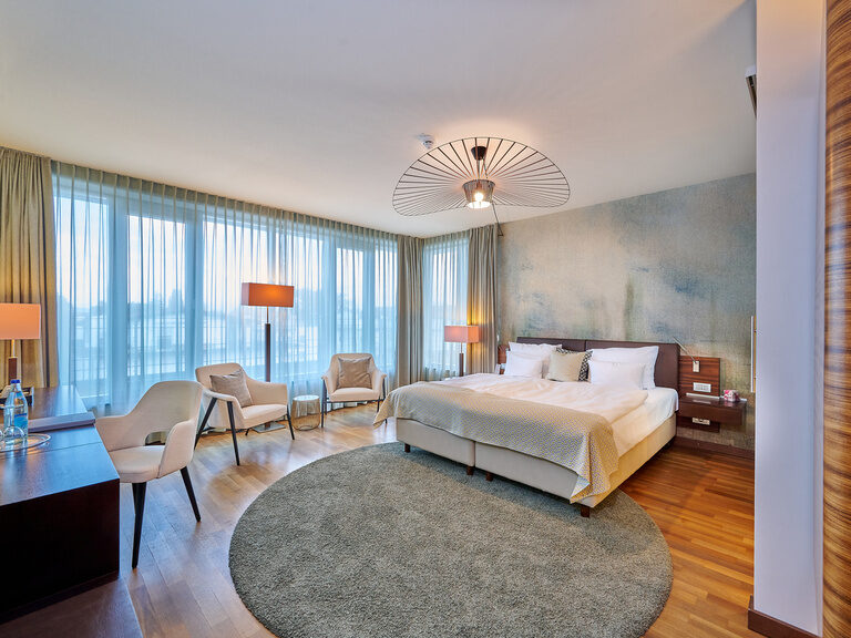 4-Sterne-S Hotel Asam Straubing: Superior-Zimmer, modern, komfortabel, Parkettboden, dunkles Holz und Blautöne.