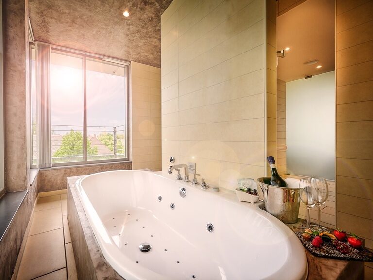 Whirlpool-Badewanne in der Hochzeitssuite des 4-Sterne-S Hotel Asam Straubing mit Blick über die Dächer der Stadt.